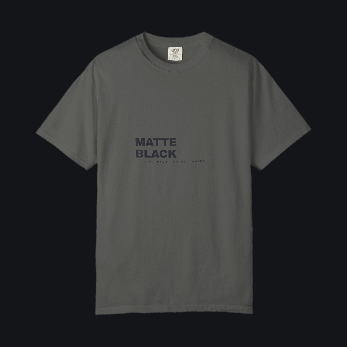 Matte Black Tee — Comfort Colors Pepper, tonal MATTE BLACK chest print, shown on the Jacob Day studio ground